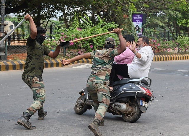 members of the karnataka reserve police force swing their sticks locally known as quot lathi quot to beat two men on a scooter who rode too close to a barricade set up on a street in mangalore photo afp members of the karnataka reserve police force swing their sticks locally known as quot lathi quot to beat two men on a scooter who rode too close to a barricade set up on a street in mangalore photo afp