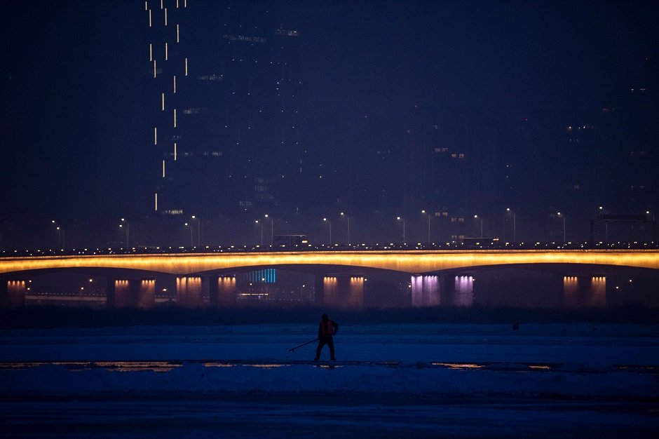 this photo taken on december 10 2019 shows a worker on the frozen songhua river in harbin in china 039 s northeastern heilongjiang province ahead of the harbin international ice and snow festival photo afp