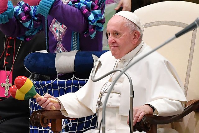 pope francis holds a maraca percussion instrument as he watches artists form a cuban circus perform during the weekly general audience on january 8 2020 at paul vi hall in the vatican photo afp