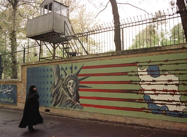 a file photo taken on november 03 1999 shows an iranian woman walking past an anti us mural at the former us embassy in tehran photo afp