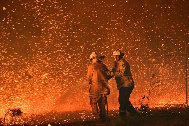 this picture taken on december 31 2019 shows firefighters struggling against the strong wind in an effort to secure nearby houses from bushfires near the town of nowra in the australian state of new south wales photo afp this picture taken on december 31 2019 shows firefighters struggling against the strong wind in an effort to secure nearby houses from bushfires near the town of nowra in the australian state of new south wales photo afp
