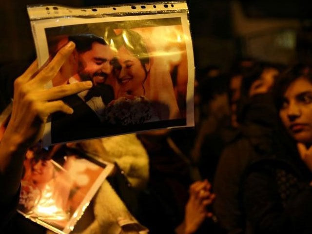 a woman holds a picture of newlyweds victims of the crash of the boeing 737 800 plane flight ps 752 as people gather to show their sympathy in tehran iran january 11 2020 photo reuters