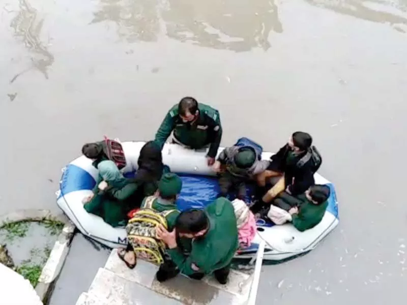 commuters wait for transport as schoolchildren trudge in downpour while rescue workers evacuate people from a school building photos express agencies commuters wait for transport as schoolchildren trudge in downpour while rescue workers evacuate people from a school building photos express agencies