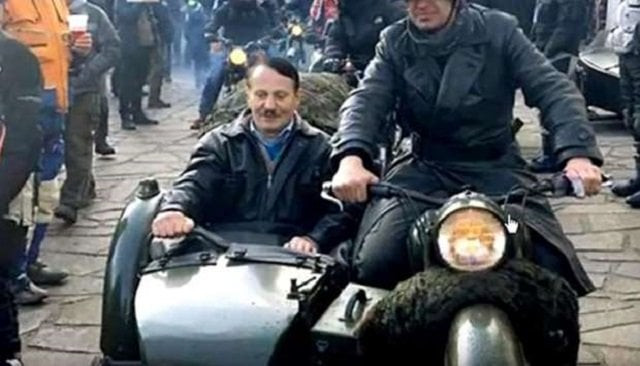 he sported a toothbrush moustache and was seated in the sidecar of a bike driven by a man dressed as a 1940s era soldier complete with world war ii style helmet screen grab he sported a toothbrush moustache and was seated in the sidecar of a bike driven by a man dressed as a 1940s era soldier complete with world war ii style helmet screen grab