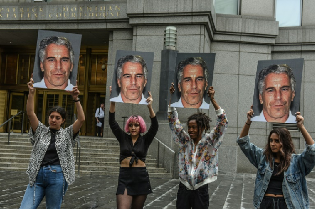 people holding up posters of the accused jeffrey epstein photo afp