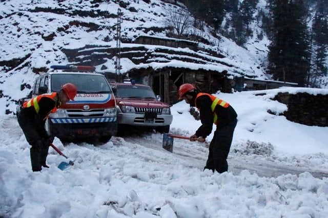 rescue workers clear a snow covered road to make way for an ambulance to reach the areas affected by heavy snowfall and avalanches in neelum valley photo reuters