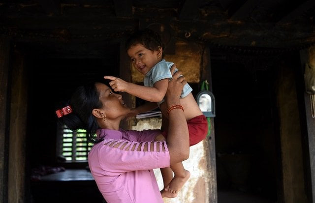 asha charti karki who got married at age 16 and mentors young girls on the importance of education plays with her daughter in their home in barahataal in surkhet district photo afp asha charti karki who got married at age 16 and mentors young girls on the importance of education plays with her daughter in their home in barahataal in surkhet district photo afp