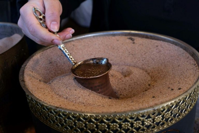 an iraqi kurdish woman prepares syrian coffee in a shop in arbil 039 s central bazar photo afp