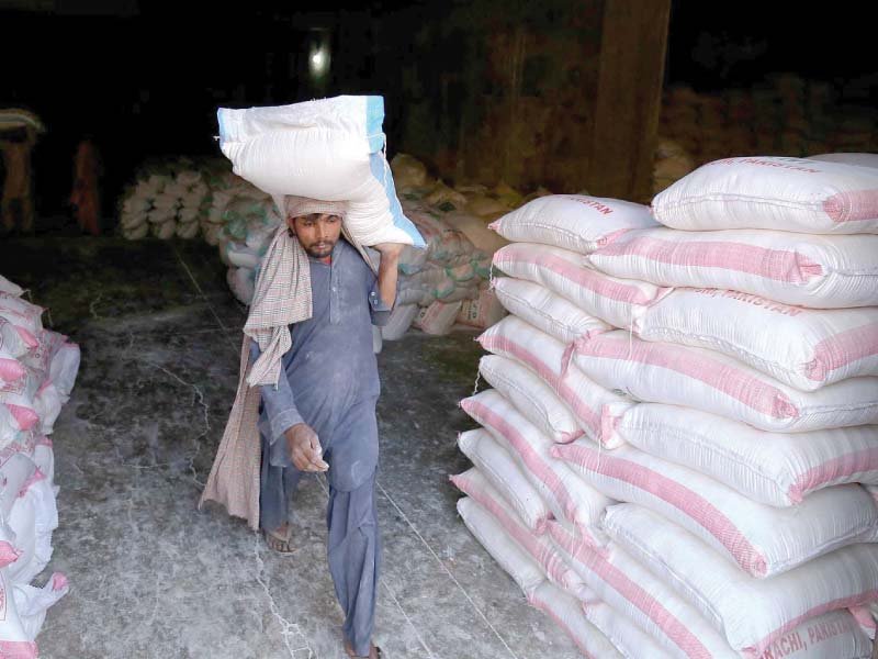 a labourer hauls a sack of wheat flour at a godown in karachi photo inp