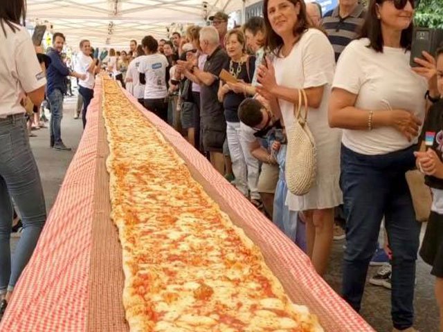 people look on as a 100m long margherita pizza sits on a table before receiving its final toppings which was prepared by pellegrini 039 s italian restaurant in their attempt to set a new record for australia 039 s longest pizza as part of a charity event to raise funds for the new south wales rural fire service in sydney australia january 19 2020 photo reuters