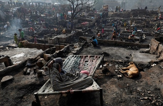a woman sits on a broken bed with her family dog on the floor of a burnt out house as people search for their belongings after a fire broke out in a slum in karachi photo reuters a woman sits on a broken bed with her family dog on the floor of a burnt out house as people search for their belongings after a fire broke out in a slum in karachi photo reuters