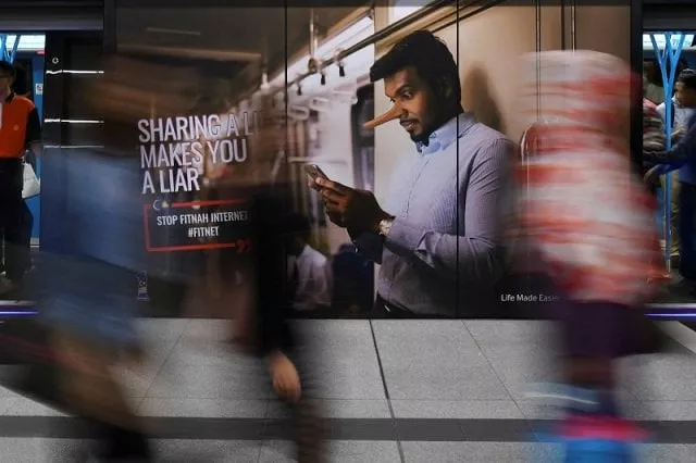 commuters walk past an advertisement discouraging the dissemination of fake news at a train station in kuala lumpur malaysia march 28 2018 photo reuters commuters walk past an advertisement discouraging the dissemination of fake news at a train station in kuala lumpur malaysia march 28 2018 photo reuters