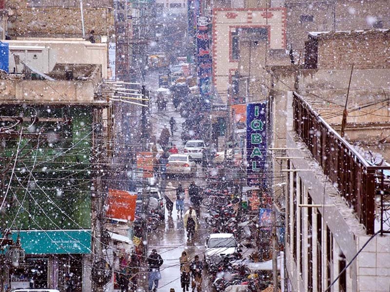 people travel in vehicles and walk in a street during snowfall in quetta photo inp