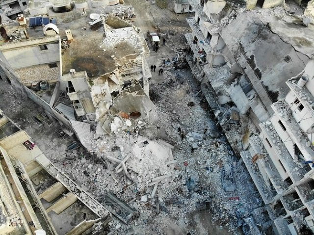 above an aerial view the rubble and debris at the site of reported airstrikes on the town of ariha in the northern countryside of syria s idlib province on january 30 2020 photo afp