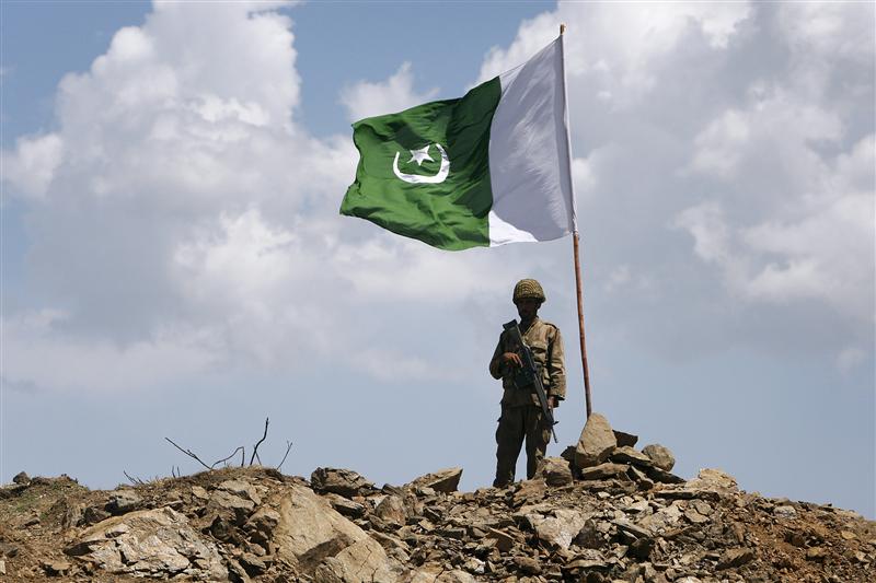 a pakistani soldier poses for a photo under pakistan 039 s national flag planted atop the baine baba ziarat mountain in swat district photo reuters