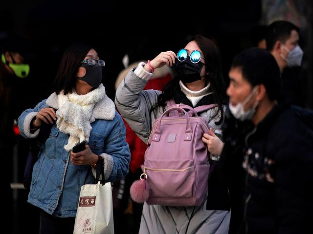 passengers wearing masks walk outside the shanghai railway station in shanghai china as the country is hit by an outbreak of a new coronavirus february 2 2020 photo reuters
