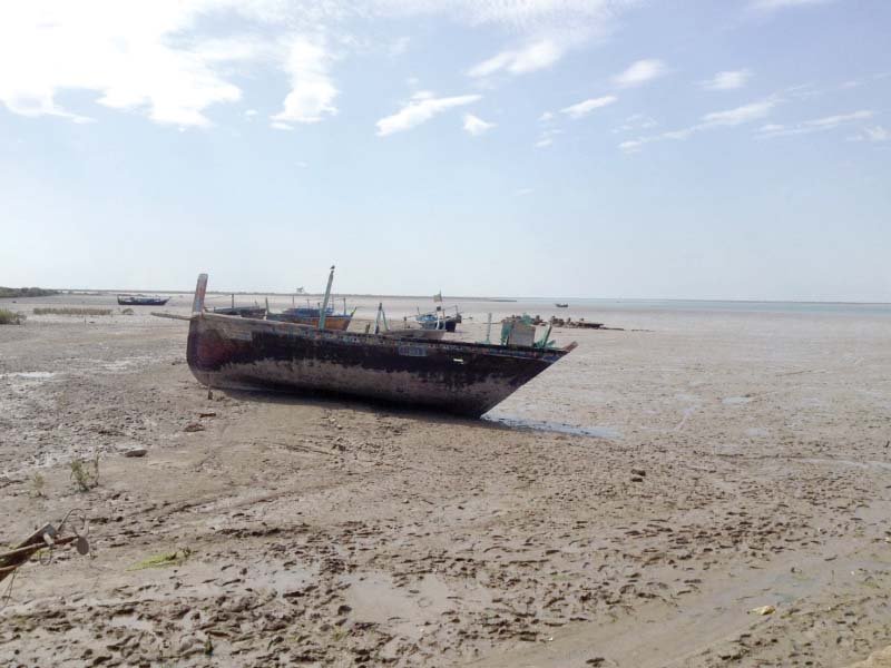 a boat stranded on the shore of thatta after a flood as a consequence of climate change frequency of floods has increased forcing entire communities living in the coastal areas to uproot themselves after every devastation fishermen along with their meagre belongings are left with little choice to move elsewhere in search of livelihood photo express