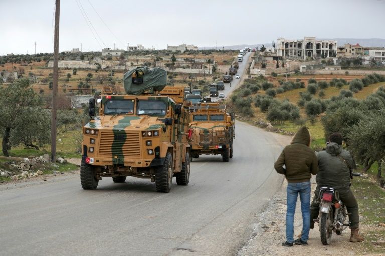 a turkish military convoy passes near idlib city on saturday as ankara vows to protect its forces in the area photo afp