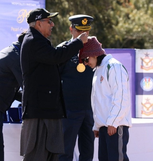 president alvi awarding medal to pakistani skier khushim sahiba during the prize distribution photo app
