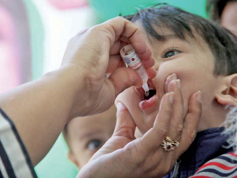 a female polio worker administers polio drops to a child in garden on the first day of a week long immunisation drive the campaign aims to vaccinate 2 3 million children across the city photo online