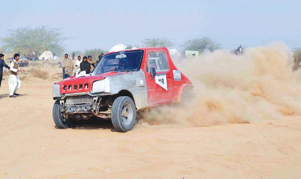 a contestant drives through sand during the cholistan jeep rally photo inp