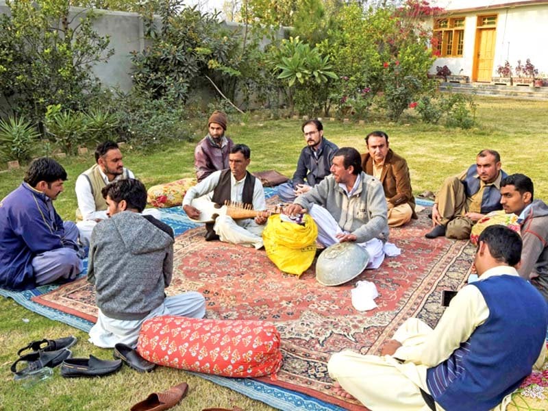 artistes sing a melodious tune with traditional musical instruments at a local residence in peshawar while a craftsman makes the traditional tamboora at his workshop photos afp