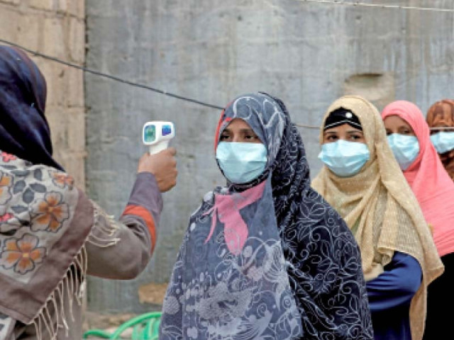 a health official checks polio workers wearing masks for fever before the immunisation drive photo reuters a health official checks polio workers wearing masks for fever before the immunisation drive photo reuters
