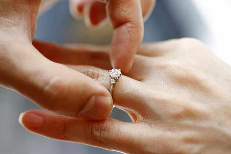 a man puts an engagement ring on a woman 039 s finger photo reuters