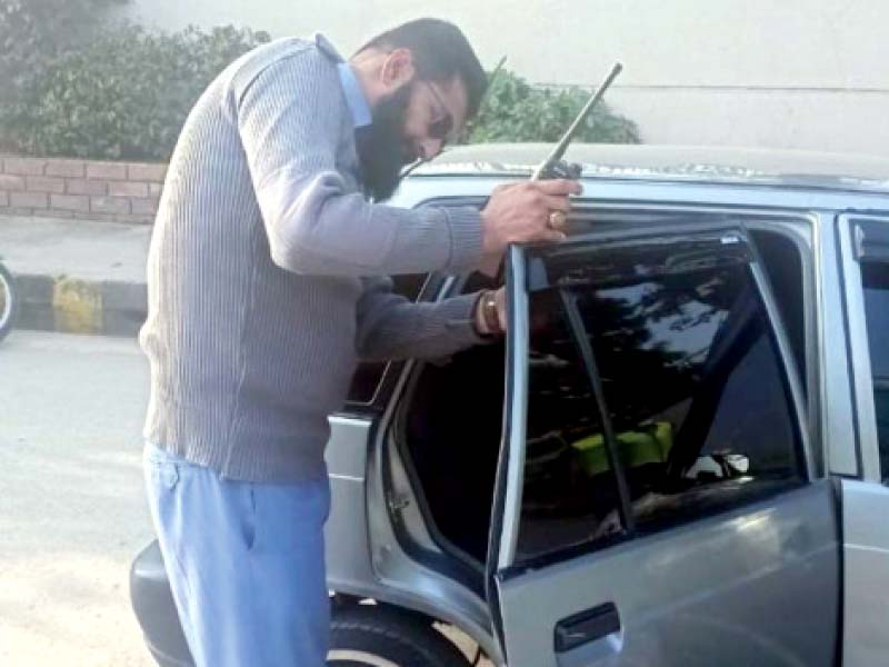 a traffic police officer removes the tint from the windows of a car during the ongoing campaign in rawalpindi photo ex press