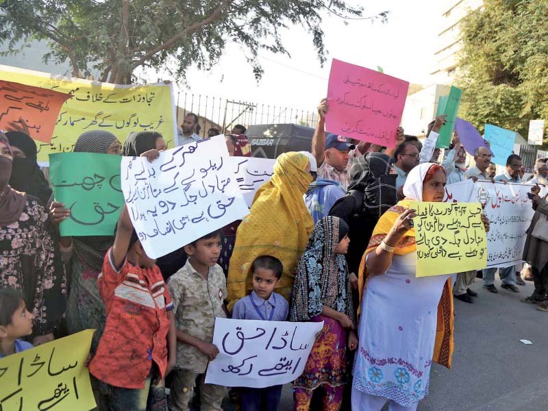 women and children affected by anti encroachment operations on land allotted for the kcr stand outside the supreme court s karachi registry on friday demanding alternative housing before their residences are razed photo ppi