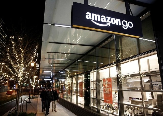 people walk by the amazon go brick and mortar grocery store without lines or checkout counters in seattle washington us december 5 2016 photo reuters