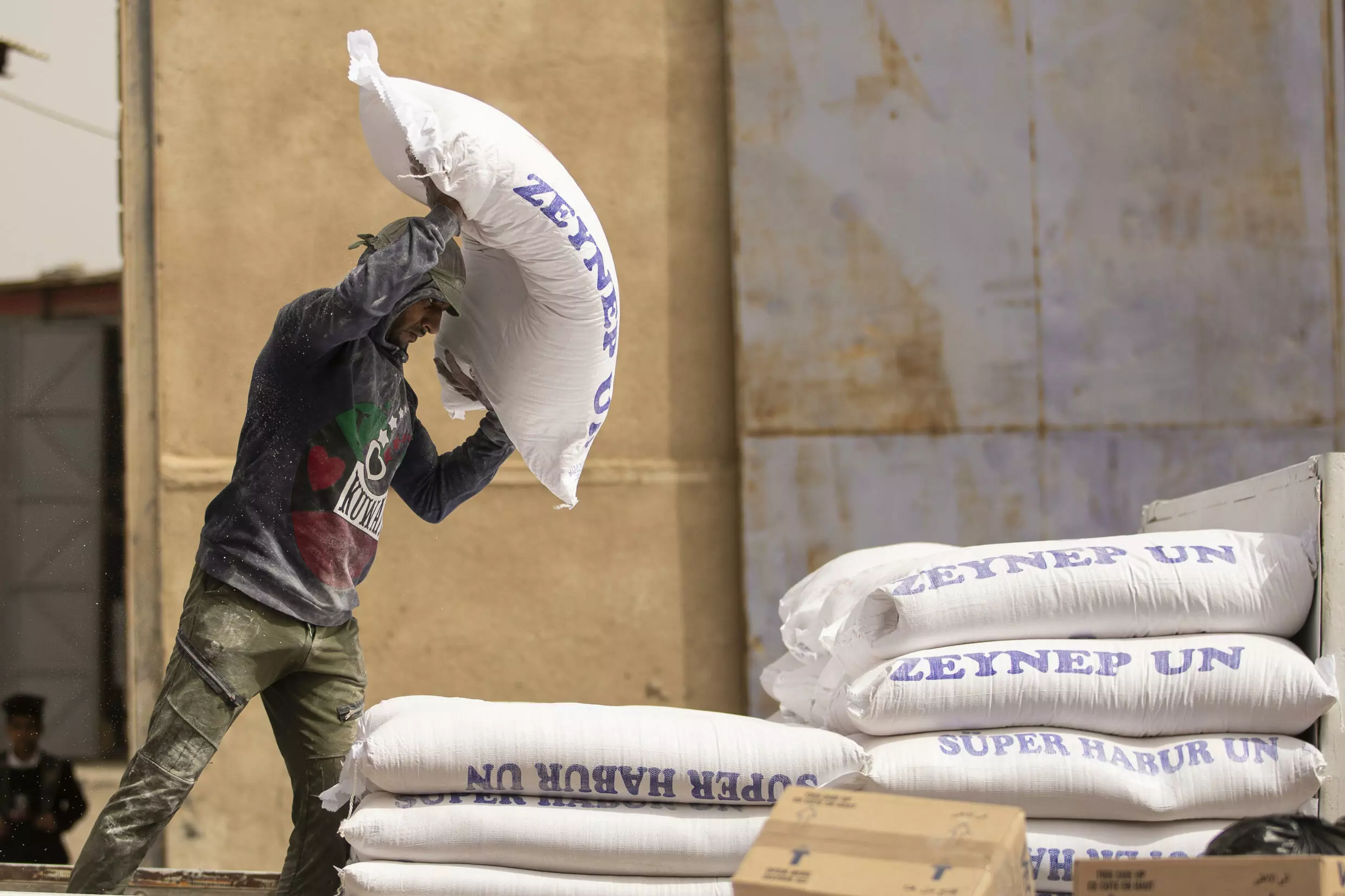 a worker piles up bags of flour inside a warehouse in iraq s southern port city of basra afp