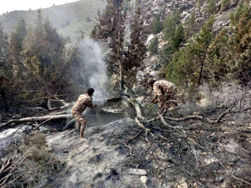 pakistan army soldiers cool off the hot spots in the koh e sulaiman mountain range after the blaze was extinguished photos express