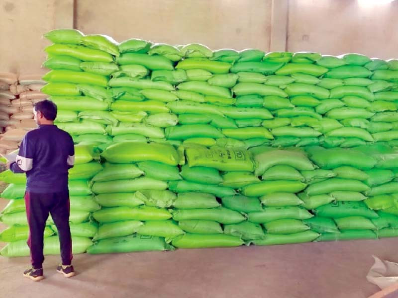 a government official inspects fertiliser bags stacked up at a warehouse photo express