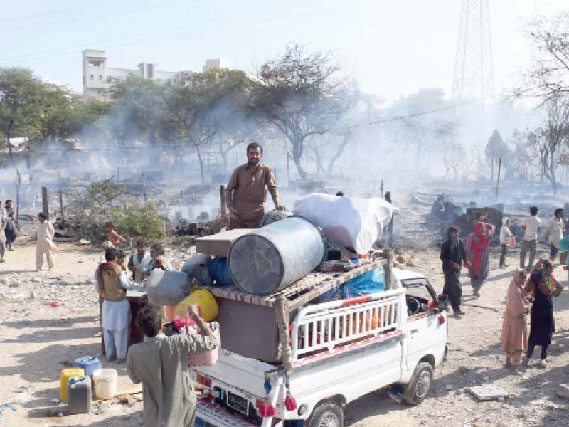 residents collect their belongings after their shanty houses caught fire during the anti encroachment operation in gulistan e jauhar photo online