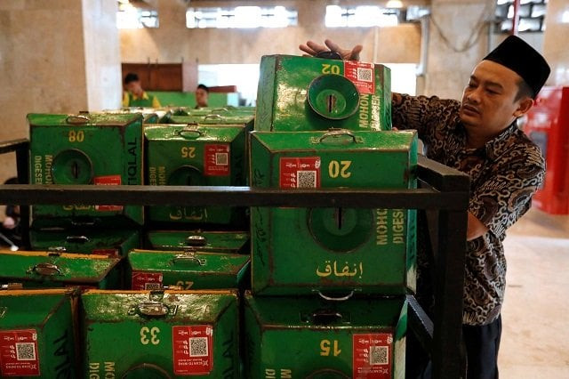 a volunteer collects alms boxes with qr codes and stacks them on a cart after friday prayers at istiqlal mosque in jakarta indonesia february 14 2020 photo reuters a volunteer collects alms boxes with qr codes and stacks them on a cart after friday prayers at istiqlal mosque in jakarta indonesia february 14 2020 photo reuters