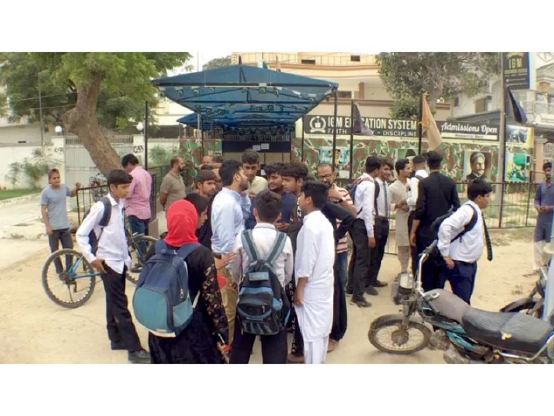 students stand outside their school in gulshan e hadeed after the institution was sealed on the directives of sindh education minister photo express students stand outside their school in gulshan e hadeed after the institution was sealed on the directives of sindh education minister photo express