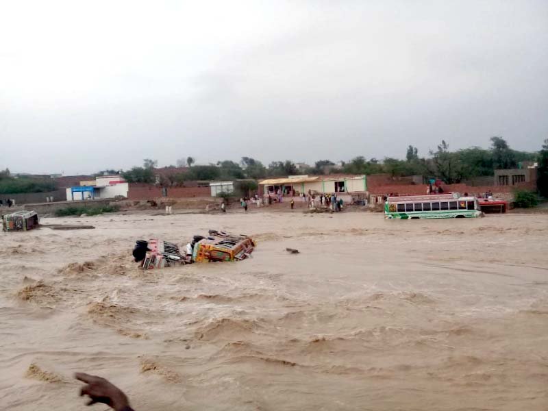 a view of buses swept away by hill torrents in dera ghazi khan photo express