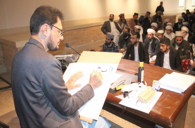 an instructor gives calligraphy lessons to students of a seminary in a workshop held by the pakistan national council of the arts photo express an instructor gives calligraphy lessons to students of a seminary in a workshop held by the pakistan national council of the arts photo express