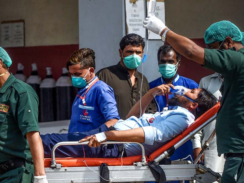 paramedic staff shifts a patient on a stretcher into the hospital in karachi on february 18 2020 photo afp file