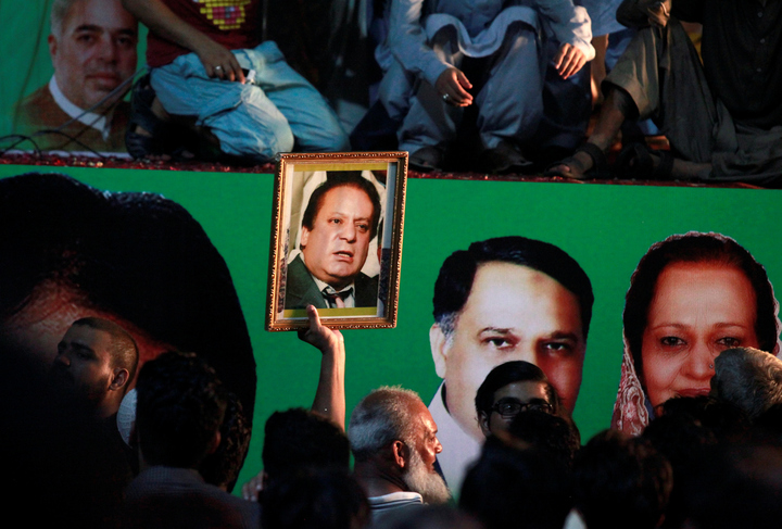 A supporter of former Pakistani prime minister Nawaz Sharif holds his picture as he waits for his convoy to pass through in Rawalpindi, Pakistan August 10, 2017. PHOTO: REUTERS