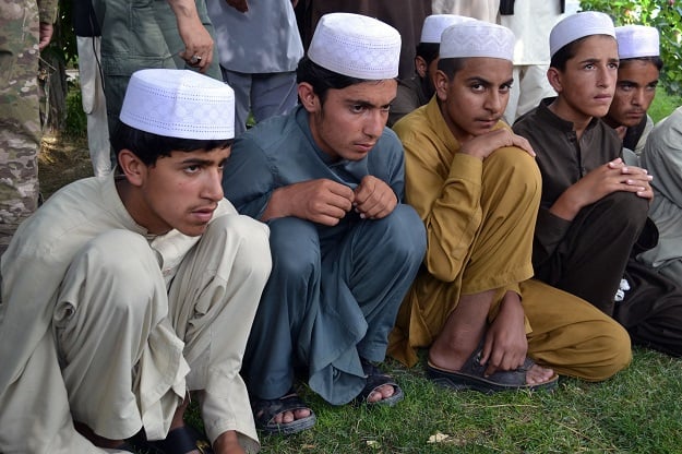 In this photograph taken on July 15, 2017, Afghan children released from captivity are presented to the media at the police headquarters in Ghazni. The rescue this summer of dozens of Afghan youths destined for Pakistan religious schools to be trained as Taliban fighters has bolstered claims that insurgents are increasingly recruiting children to reinforce their ranks PHOTO: AFP