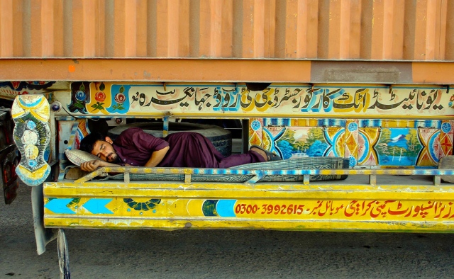 a labourer naps beneath a truck the super highway was blocked by protesters on sunday causing a massive traffic jam photo inp