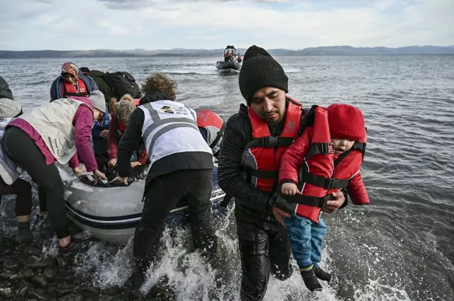 ngo members help refugees to disembark from a dinghy as it lands ashore the greek island of lesbos photo afp ngo members help refugees to disembark from a dinghy as it lands ashore the greek island of lesbos photo afp