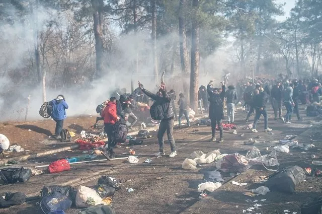 dozens of greek security officers and soldiers fired tear gas as riot police officers with batons shields and masks confronted migrants yelling at them to stay back on saturday photo afp dozens of greek security officers and soldiers fired tear gas as riot police officers with batons shields and masks confronted migrants yelling at them to stay back on saturday photo afp