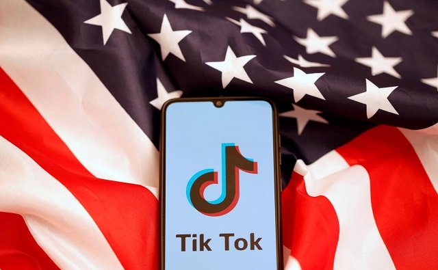 tik tok logo is displayed on the smartphone while standing on the us flag in this illustration picture taken november 8 2019 photo reuters