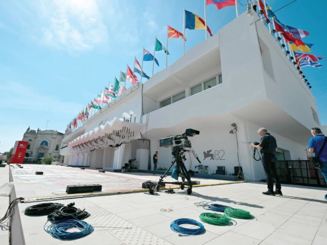 technicians work outside the palazzo del cinema that will host screenings and ceremonies during the 82nd venice film festival at venice lido photo afp