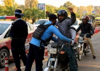 a police officer frisks a biker at a security check post along a road following yesterday s blast outside the district court building reuters