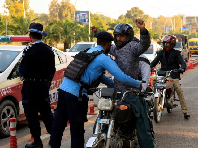 a police officer frisks a biker at a security check post along a road following yesterday s blast outside the district court building reuters