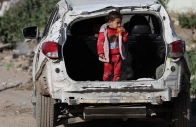a palestinian child stands in the trunk of a damaged car near a cemetery during eid al fitr in gaza city march 20 2026 reuters